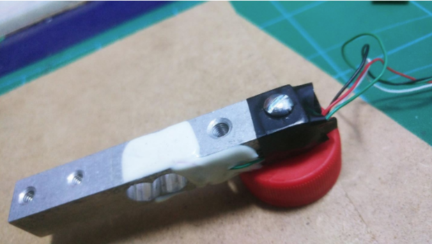Attached bottle cap with bolts to the load cell